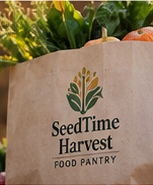 A SeedTime Harvest Food Pantry grocery bag filled with vegetables